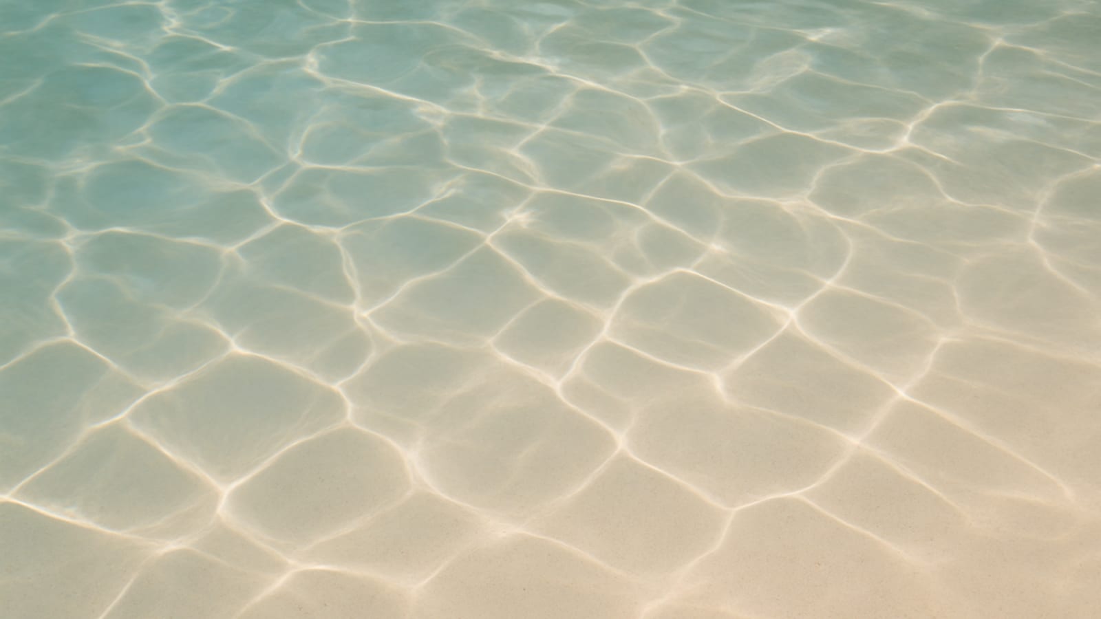Clear blue-green pool water with subtle light refraction across a pale interior finish